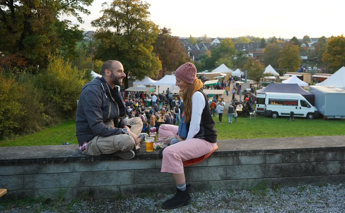 Zwei Menschen, die auf einer Mauer sitzen. 
